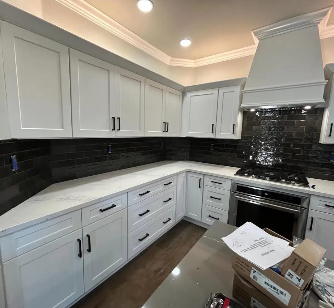 Kitchen with glossy black subway backsplash and quartz counters